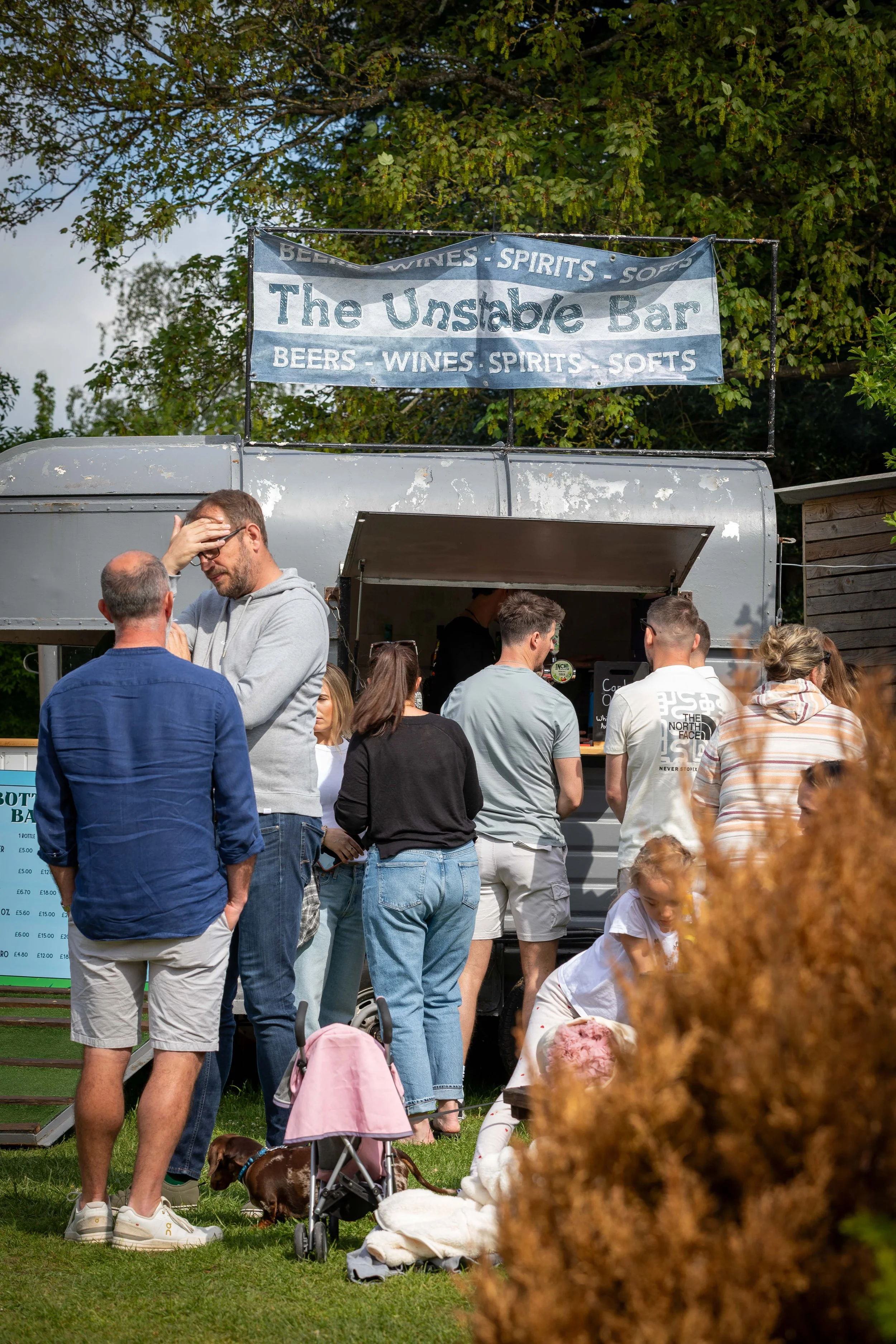 Bartender serving customers from mobile hoursebox bar at The Partridge Inn music festival in Singleton