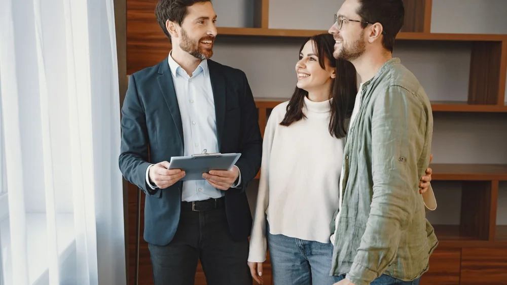 Property manager reviewing rental details with two homeowners on a tablet