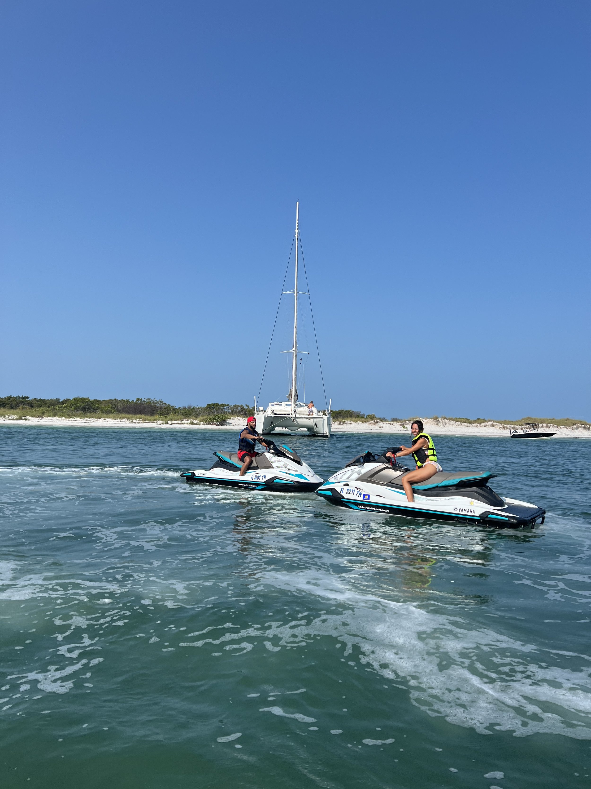 Couples on jet ski near yacht