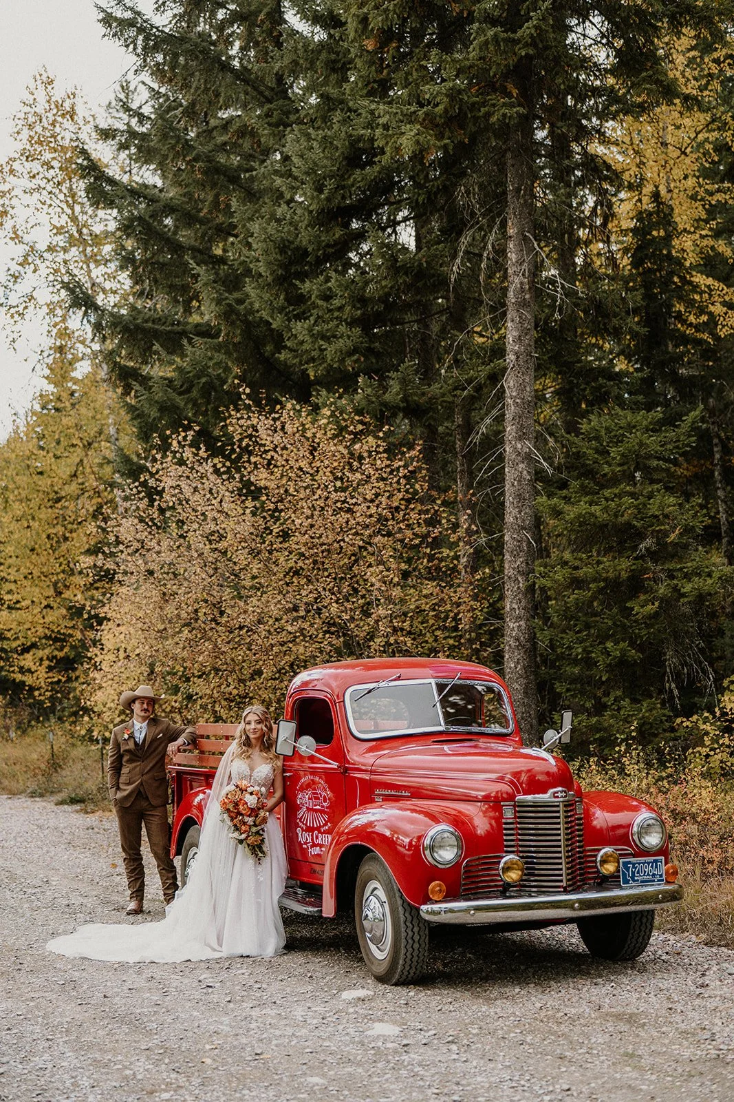 Bride and groom with a vintage red 1940s International Harvester truck from Rose Creek Farms during their Flathead Valley wedding