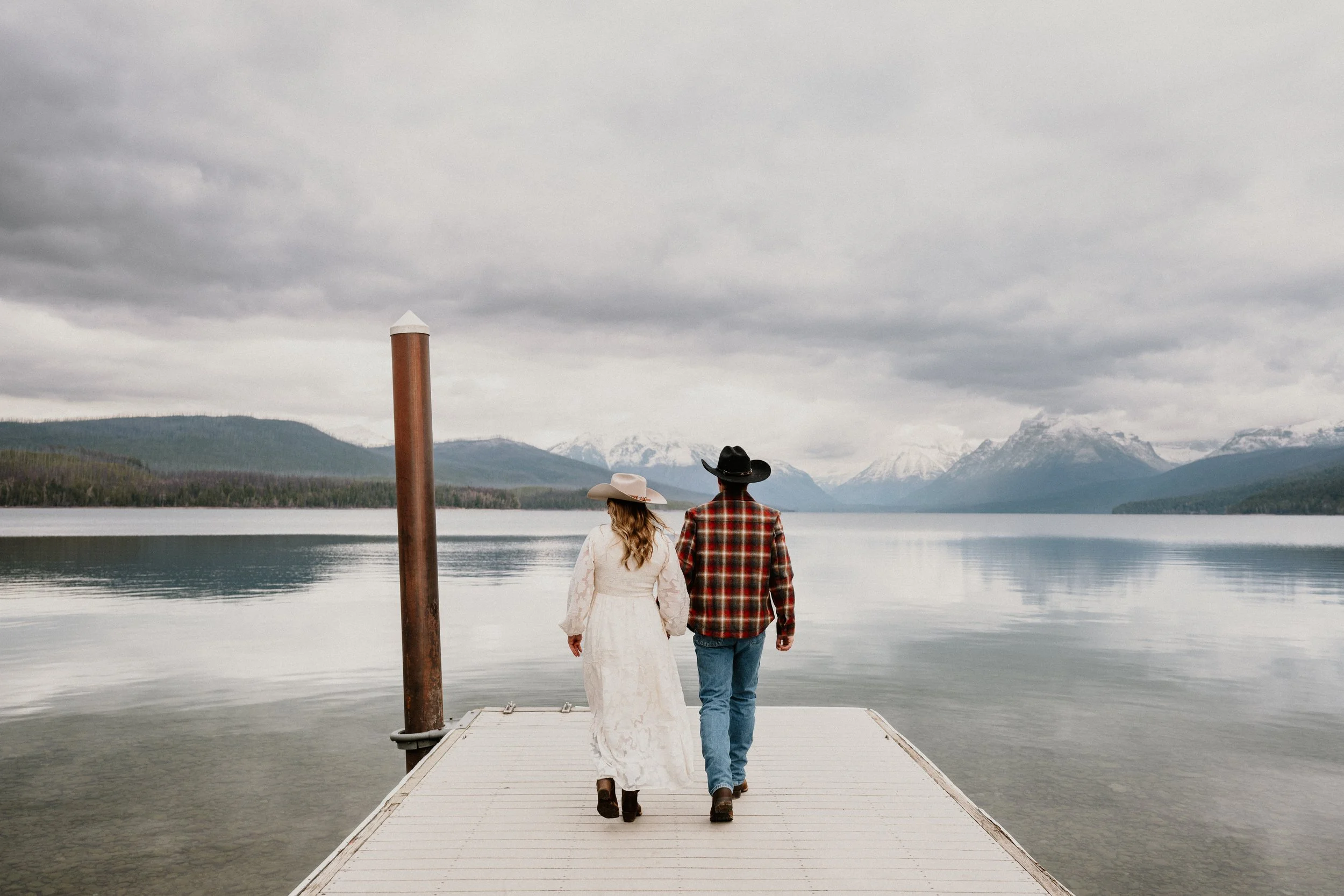 Couple walking the Apgar dock at Lake McDonald in Glacier National Park during their engagement session