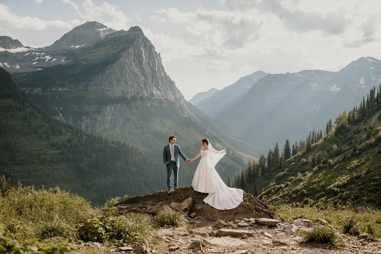 Bride and groom standing on mountain overlook during Glacier National Park elopement ceremony in Montana