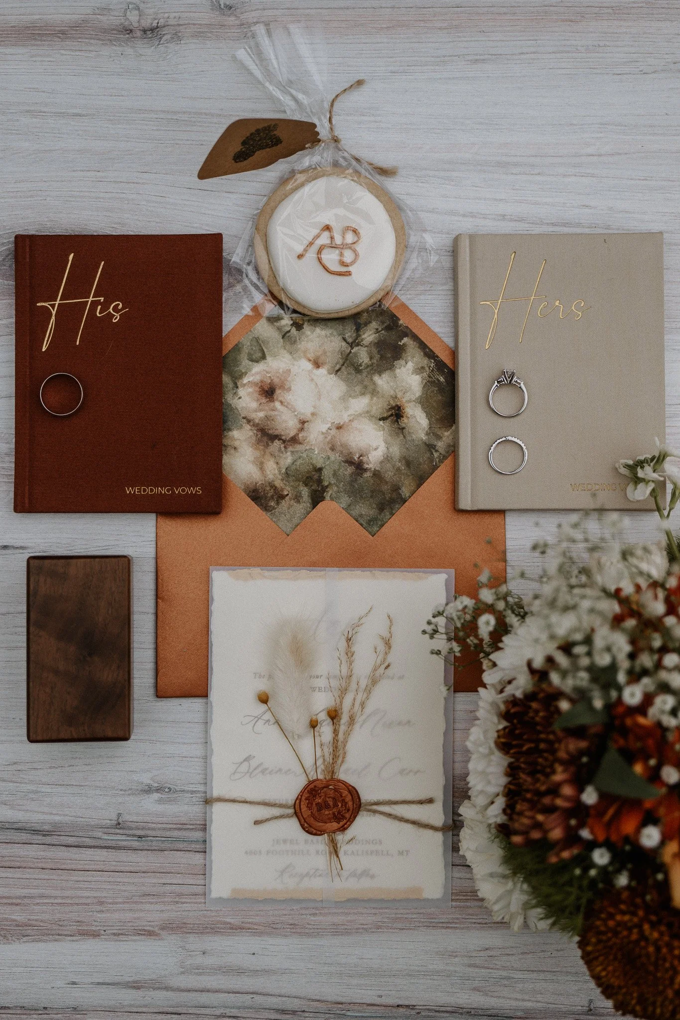 Wedding day detail flat lay with His and Hers vow books, rings, and wax-sealed invitation at Jewel Basin Weddings