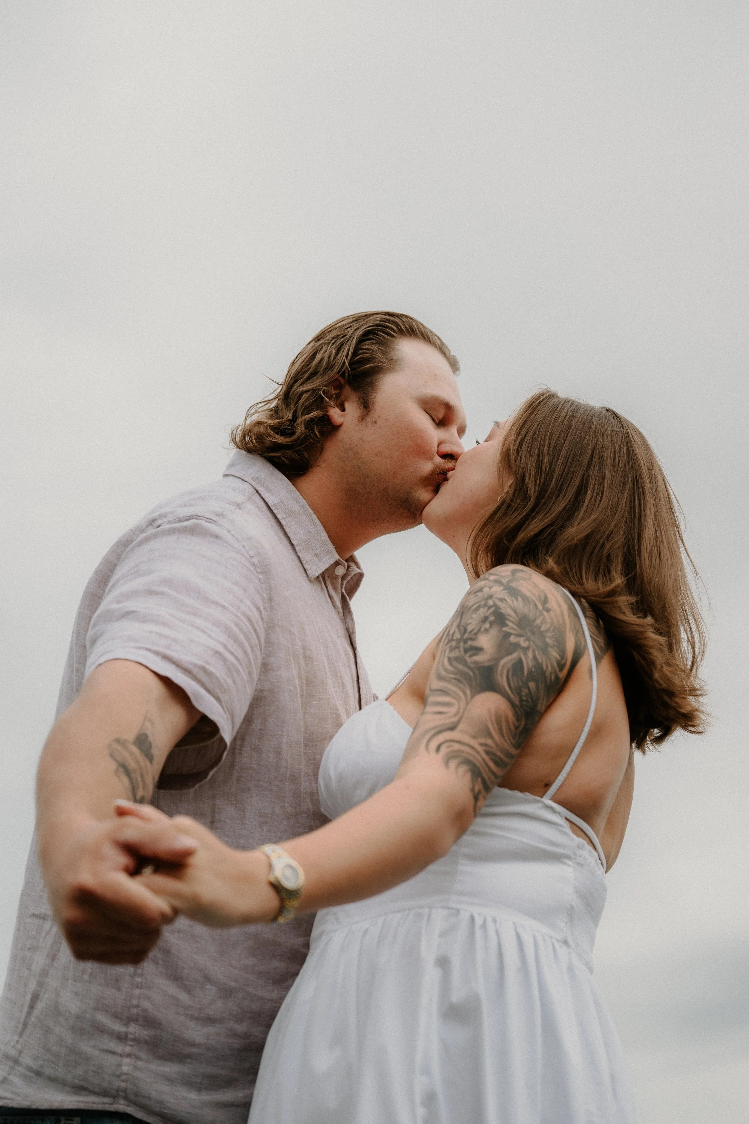 Engaged couple walking together in a West Glacier park during rainy engagement photos