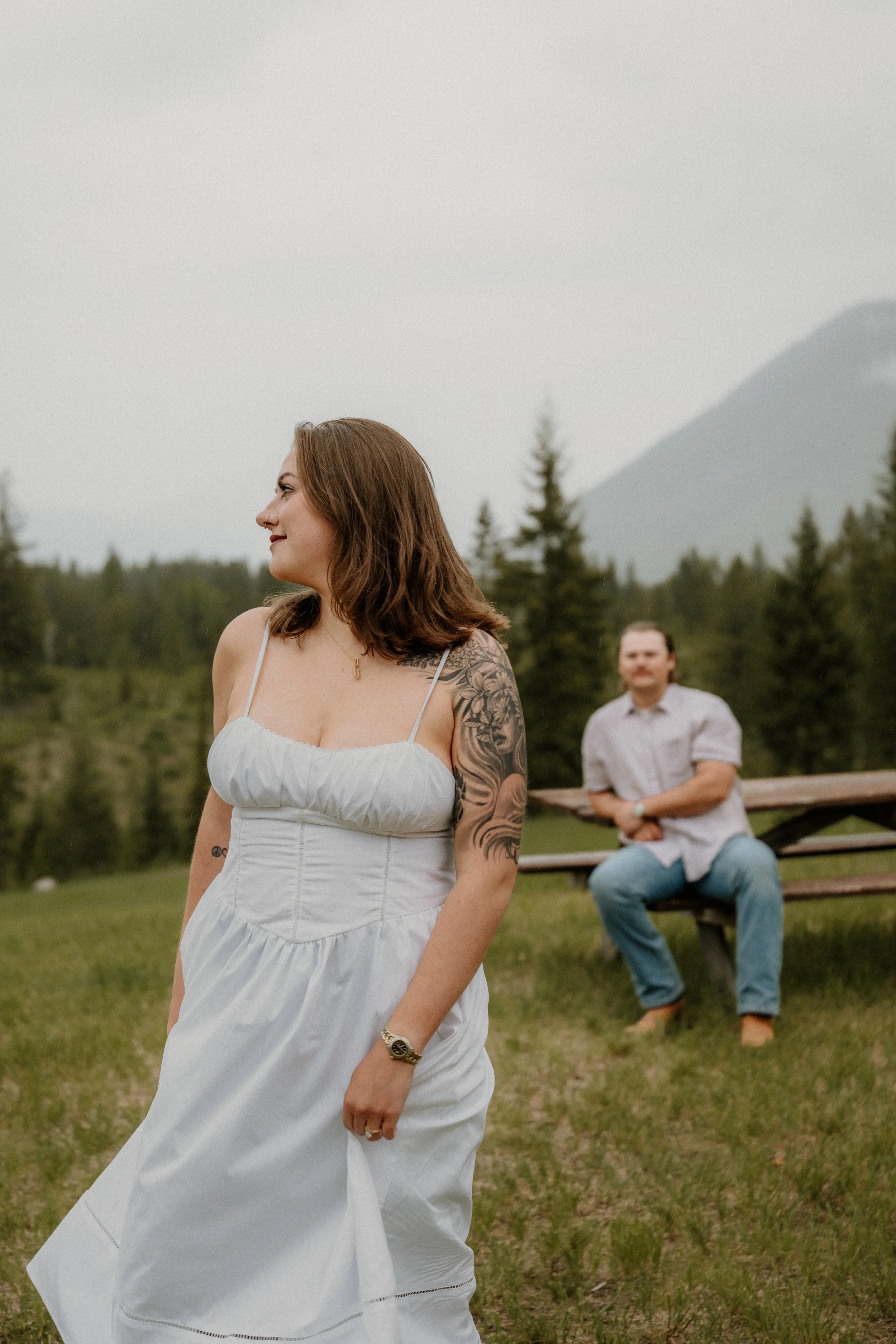 Couple kissing under rainy skies during Glacier National Park engagement photos
