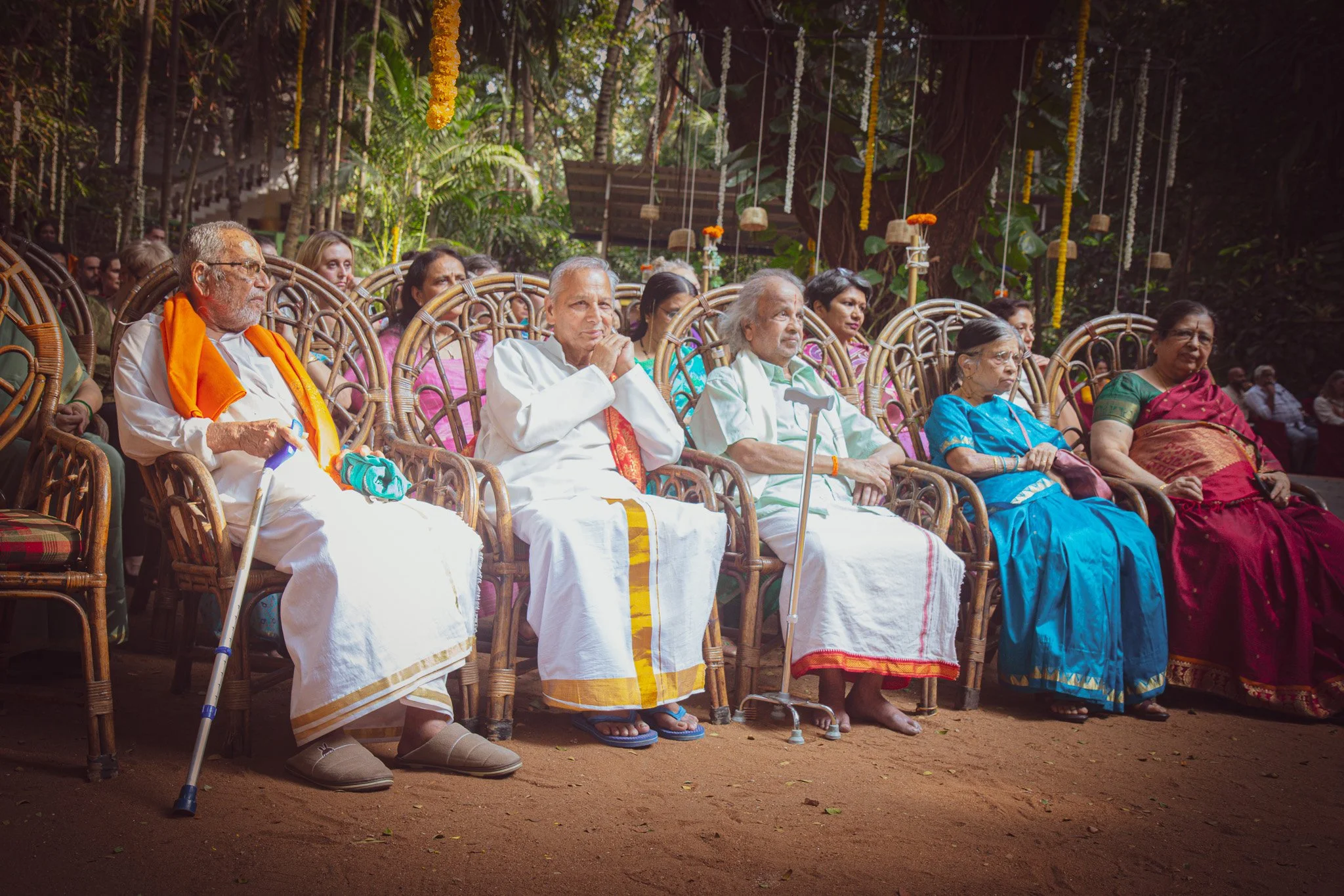 Four elders of the Mysore community seated together, listening, during a gathering