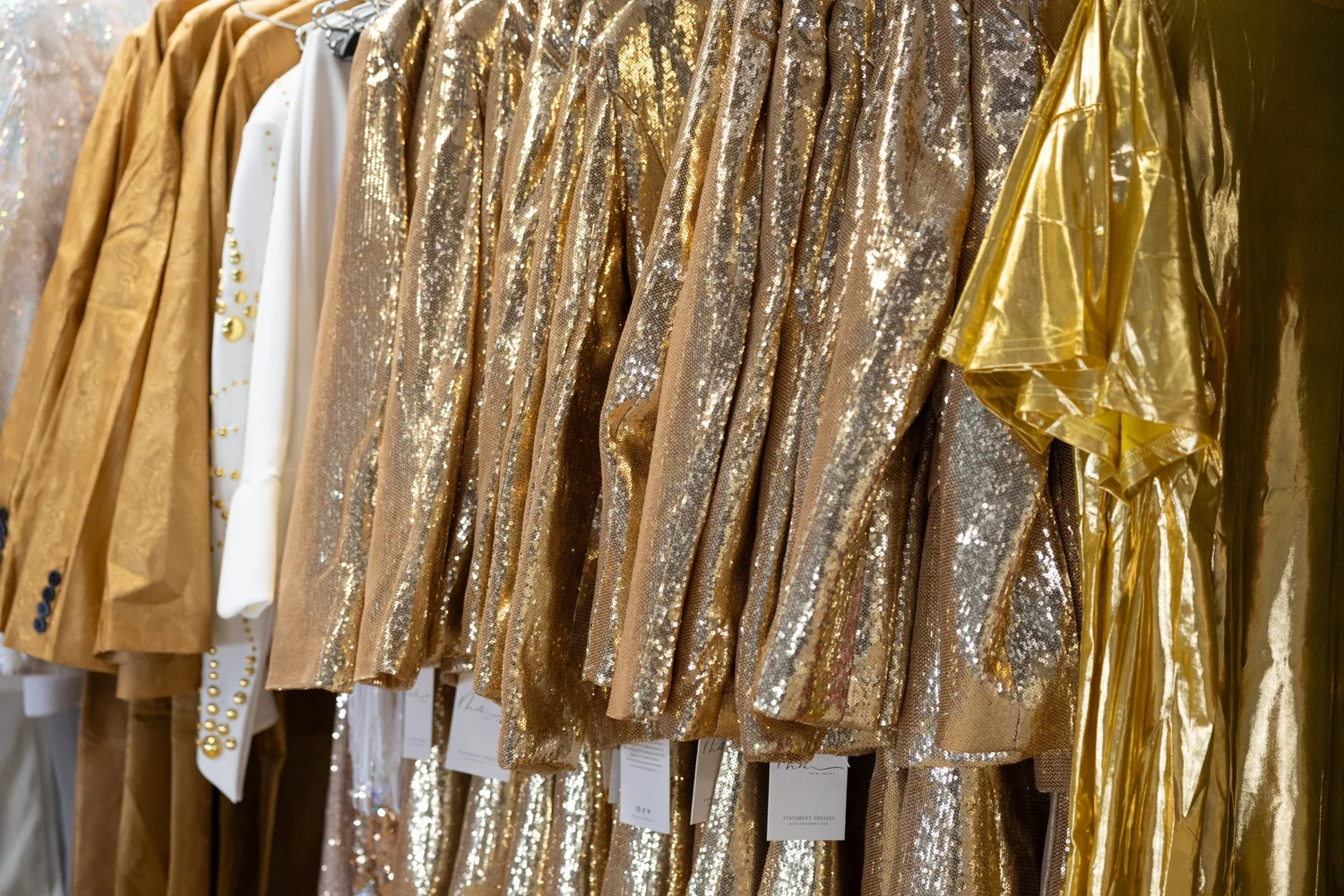 Gold sequinned costumes on the rails of the M.S.E wardrobe