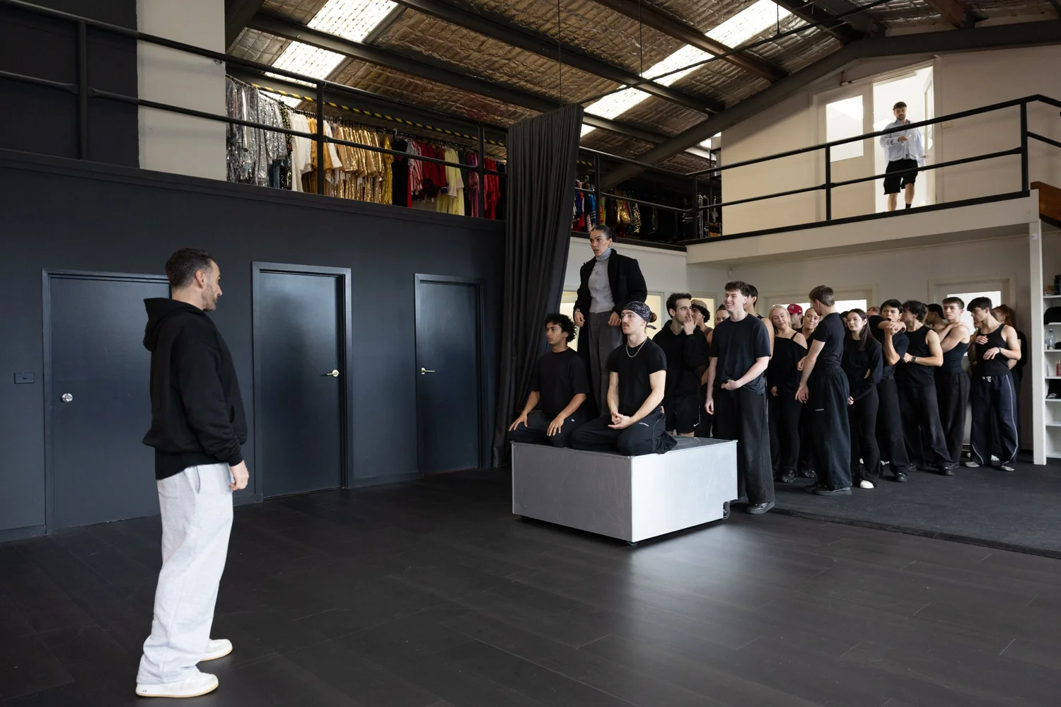 A director giving notes to a cast on the studio floor