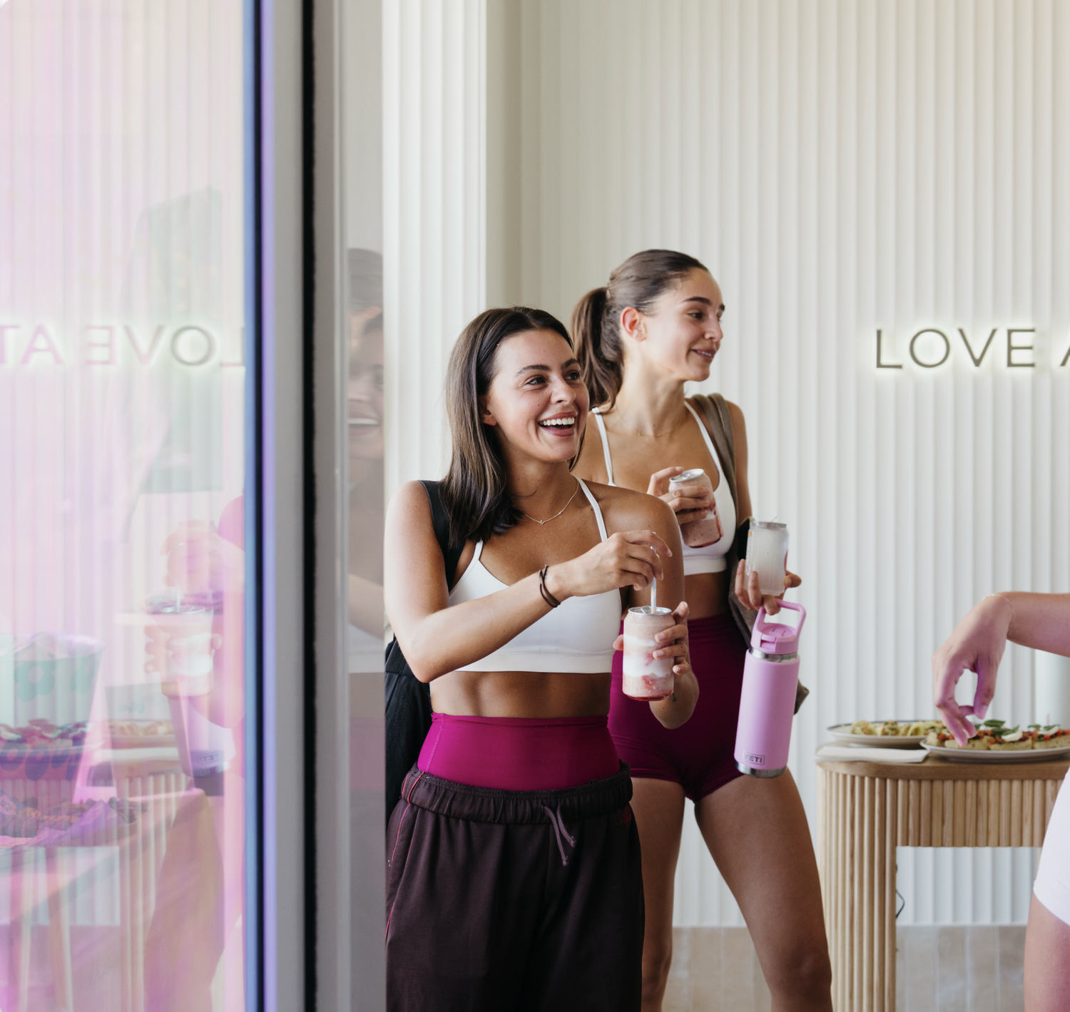 Members laughing together in the Love Athletica lounge