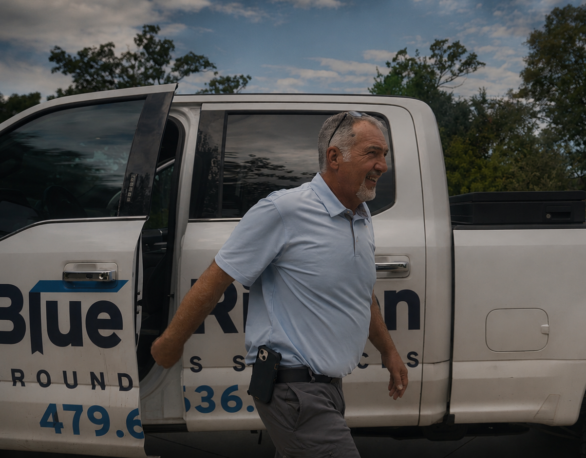 Blue Ribbon Grounds Services manager stepping out of a branded white pickup truck at a job site, an example of landscaper marketing done right.