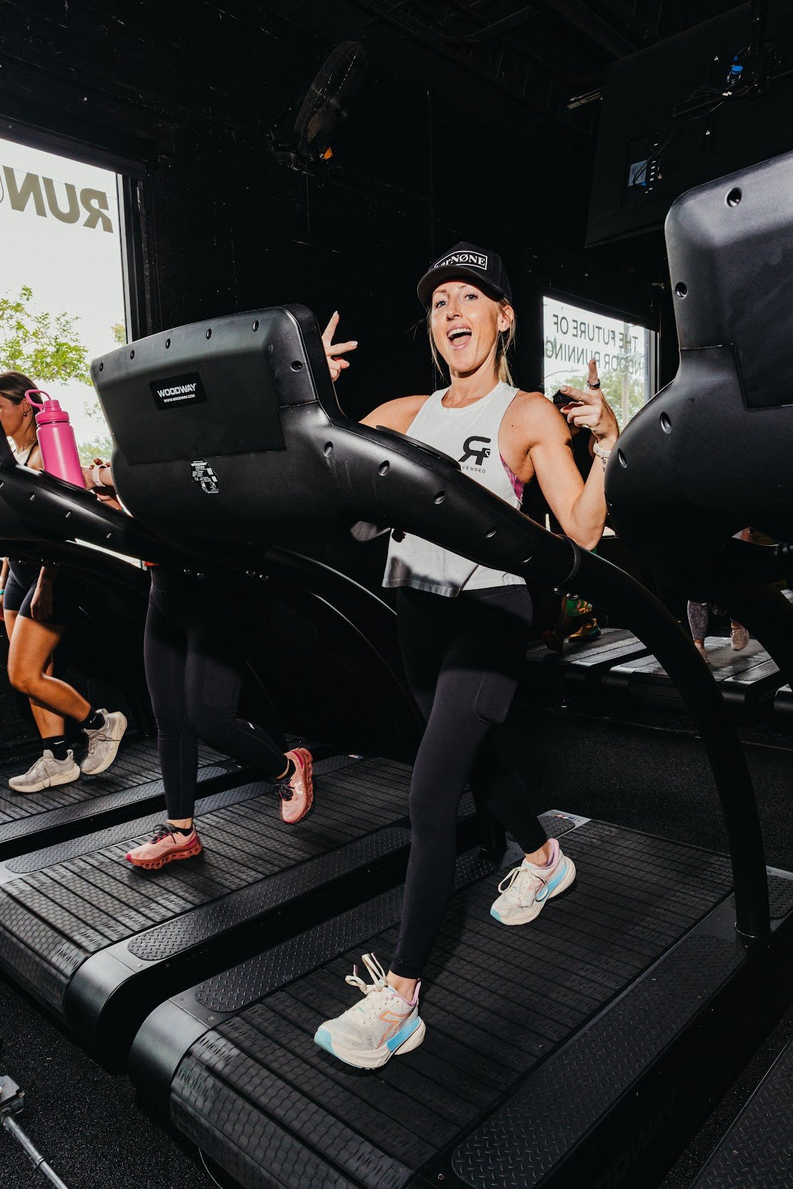 A runner mid-stride on a Woodway curved treadmill in the Run Unlimited studio.