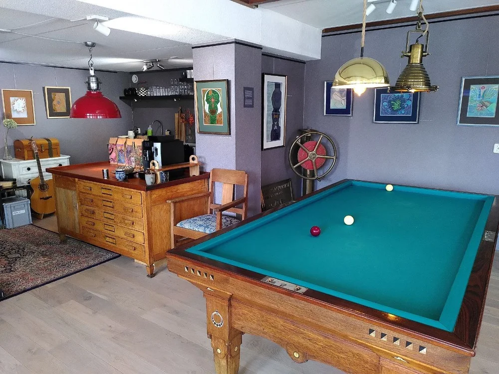 Hanzehuis Gallery in Stavoren: een biljarttafel met de galerie en de bar op de achtergrond.