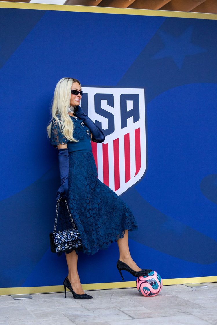 Selected image: guest posing at a team crest backdrop