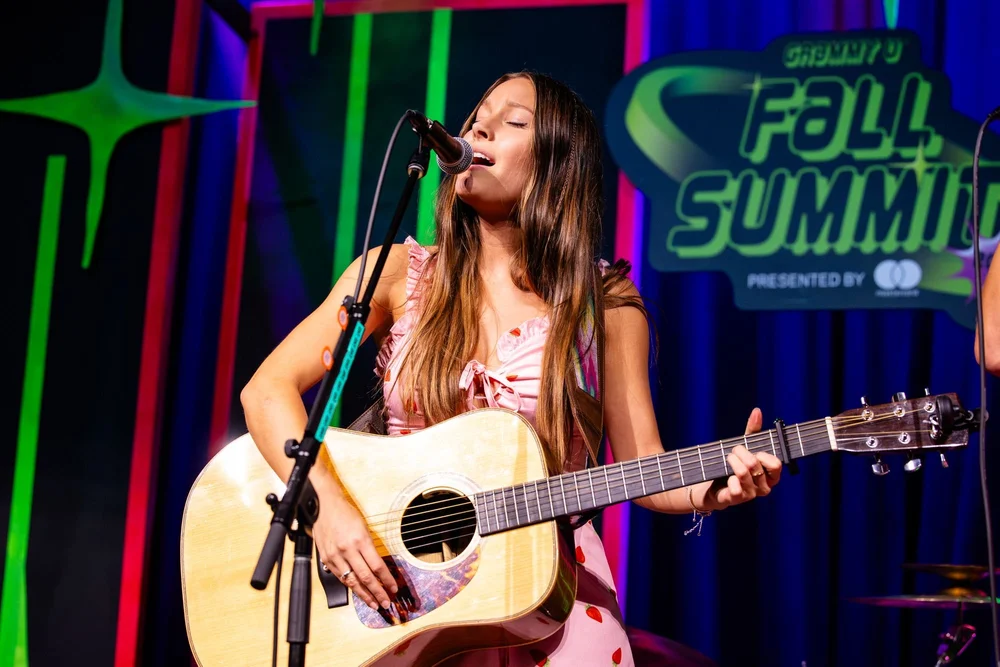 Singer performing with an acoustic guitar