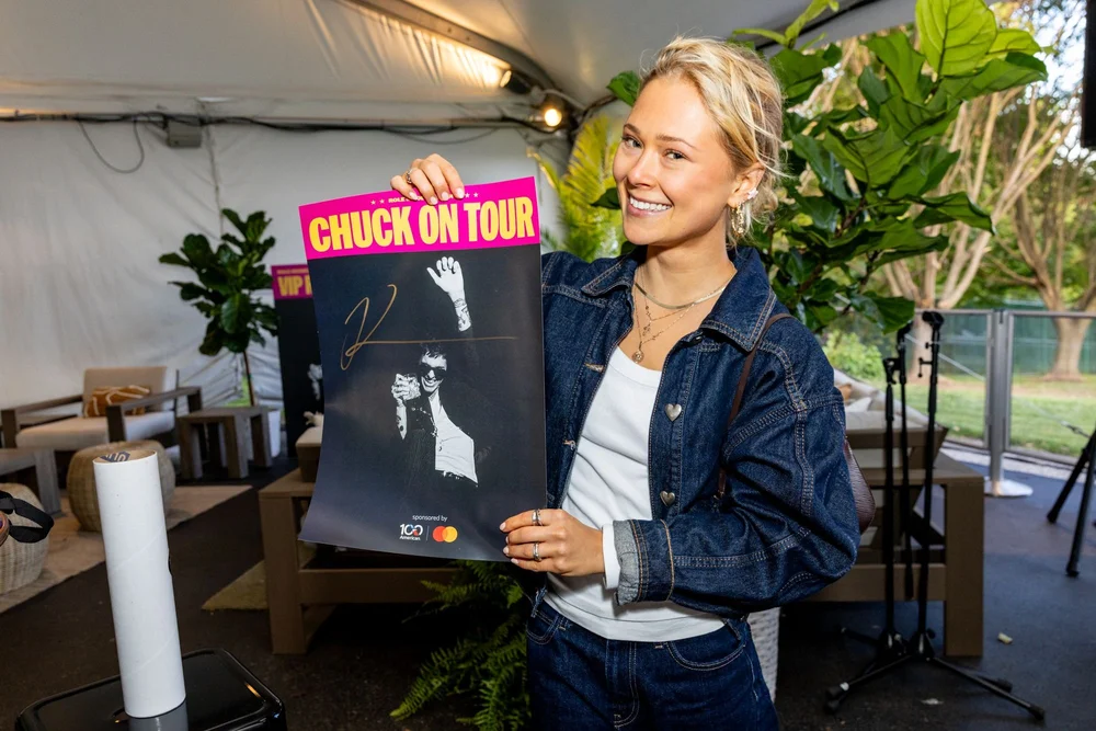Guest holding a signed tour poster
