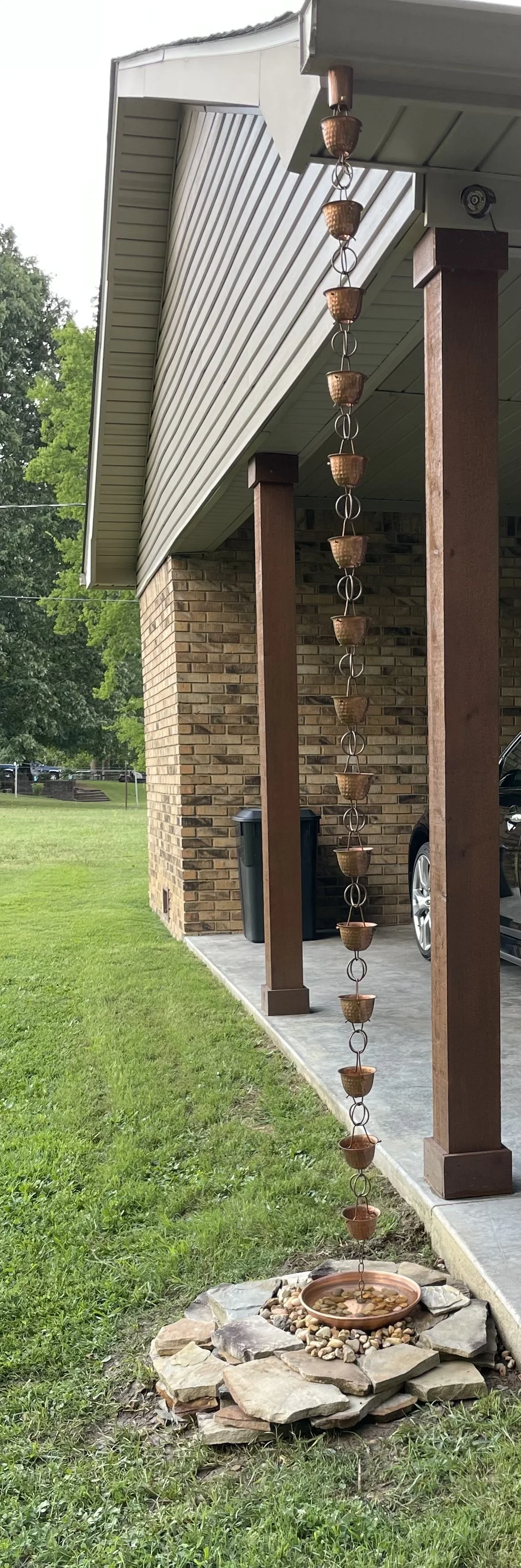 Decorative rain chain installation on home exterior