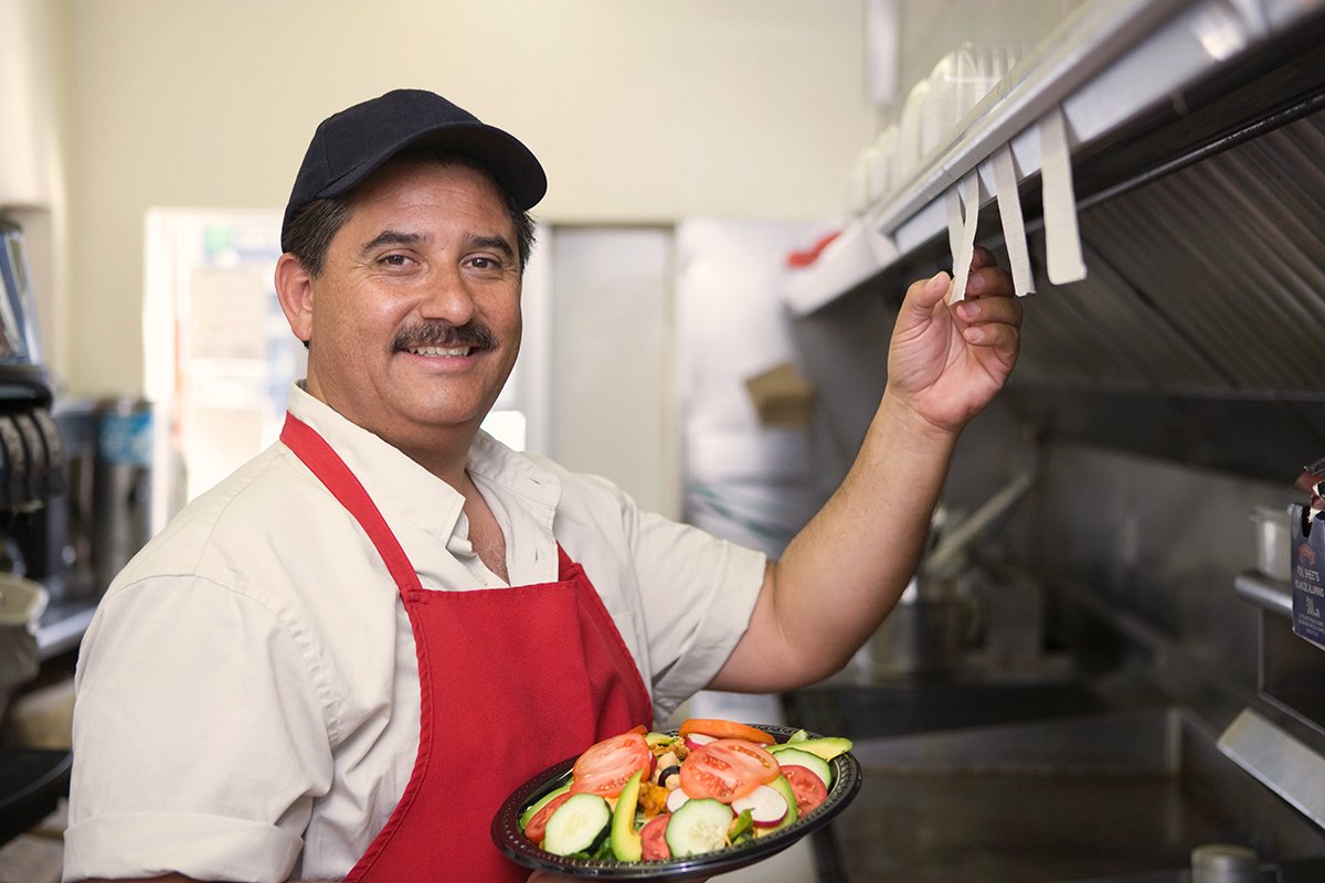 A restaurant owner about to take an order to a customer.