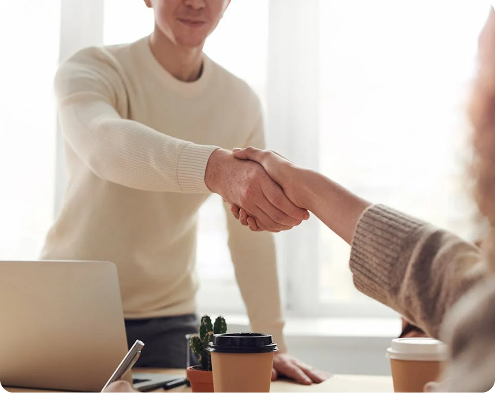 Two people in a conference room shaking hands