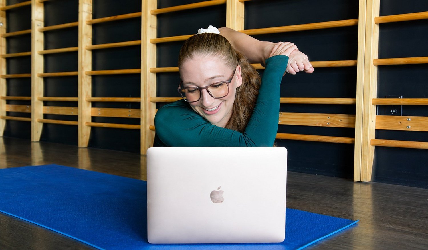 Sarah working at her laptop with one foot stretched behind her head