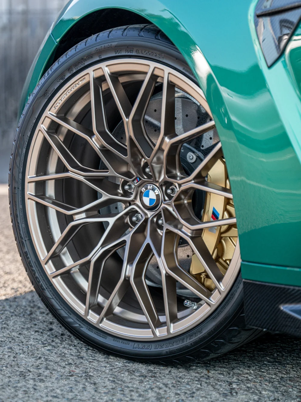 Bronze-toned front wheel and gold brake caliper on the Isle of Man Green BMW M3