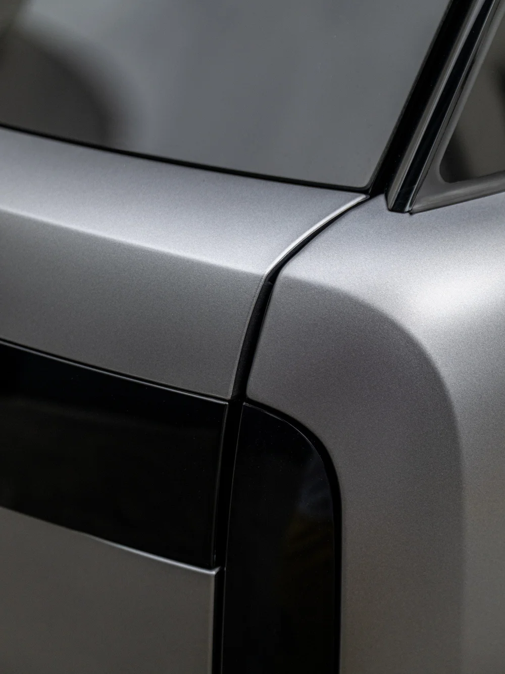 Satin Eiger Grey front fender and door junction on the Range Rover, beside the gloss black side trim and A-pillar base.
