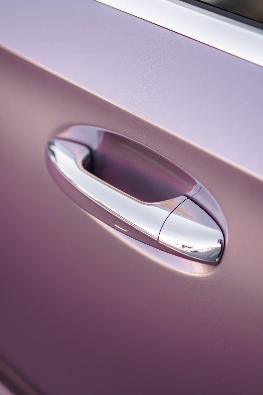 Close view of the Mercedes-Benz A 220 door handle and surrounding Frozen Berry vinyl panel
