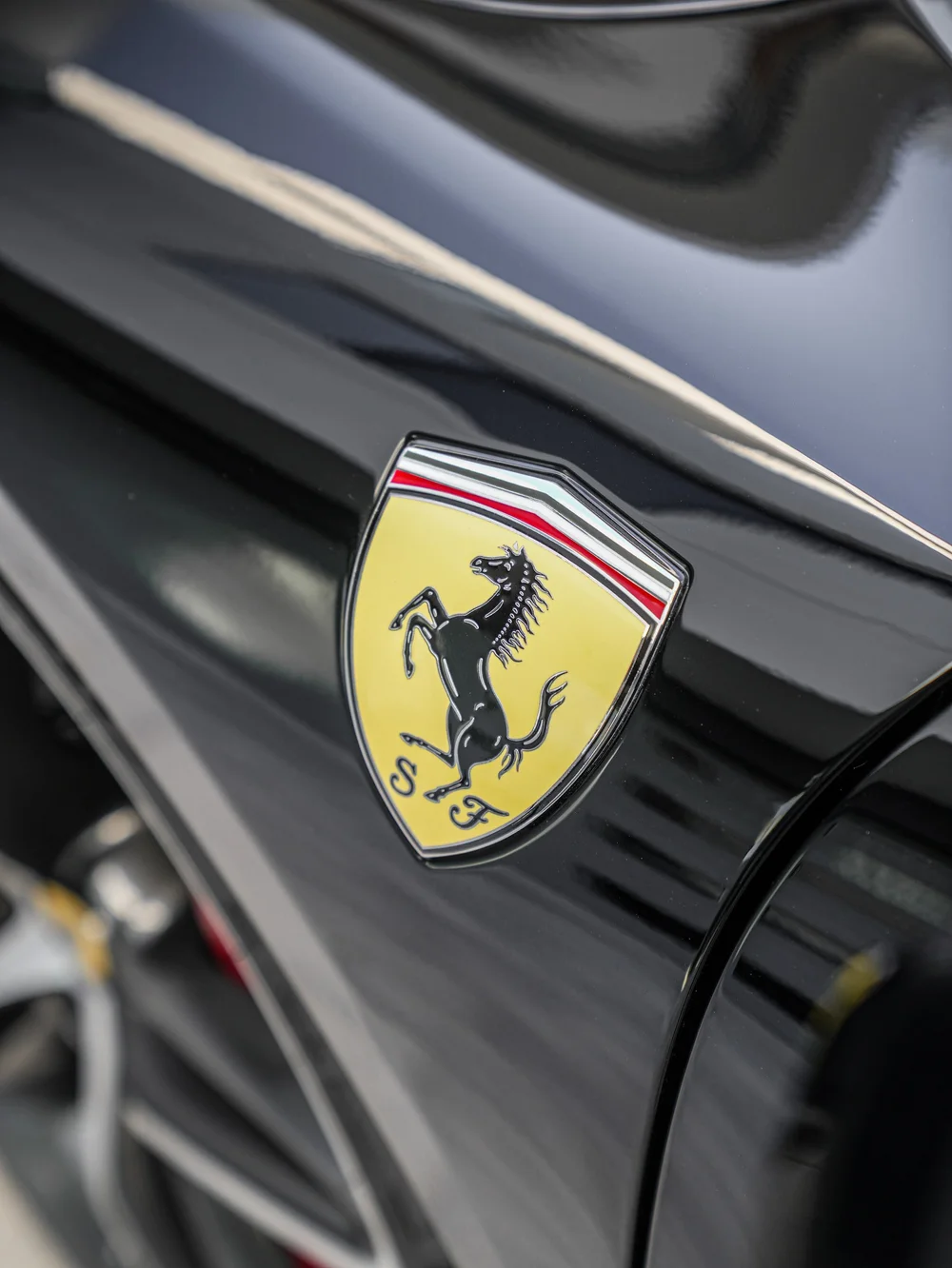 Yellow Ferrari shield emblem on reflective black bodywork