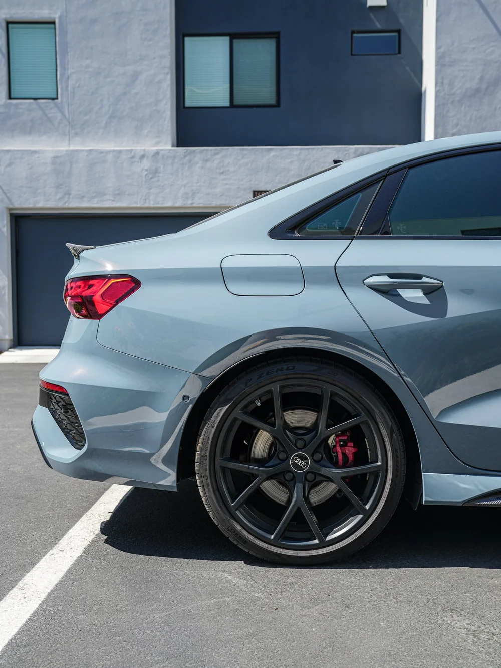 Audi RS 3 rear wheel, red brake caliper and blue-grey quarter panel
