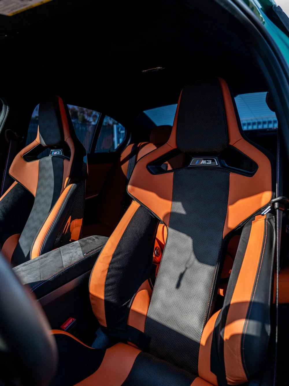 Kyalami Orange and Black front seats inside the 2025 BMW M3 Sedan