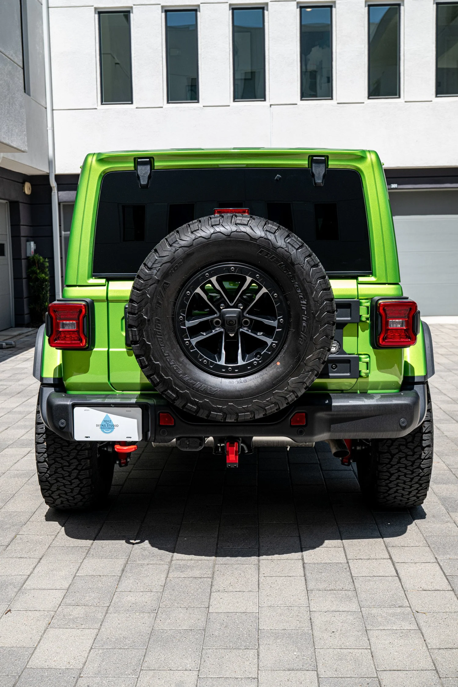 Straight rear view of the Mojito Jeep Wrangler Unlimited Rubicon with its spare tire centered on the tailgate