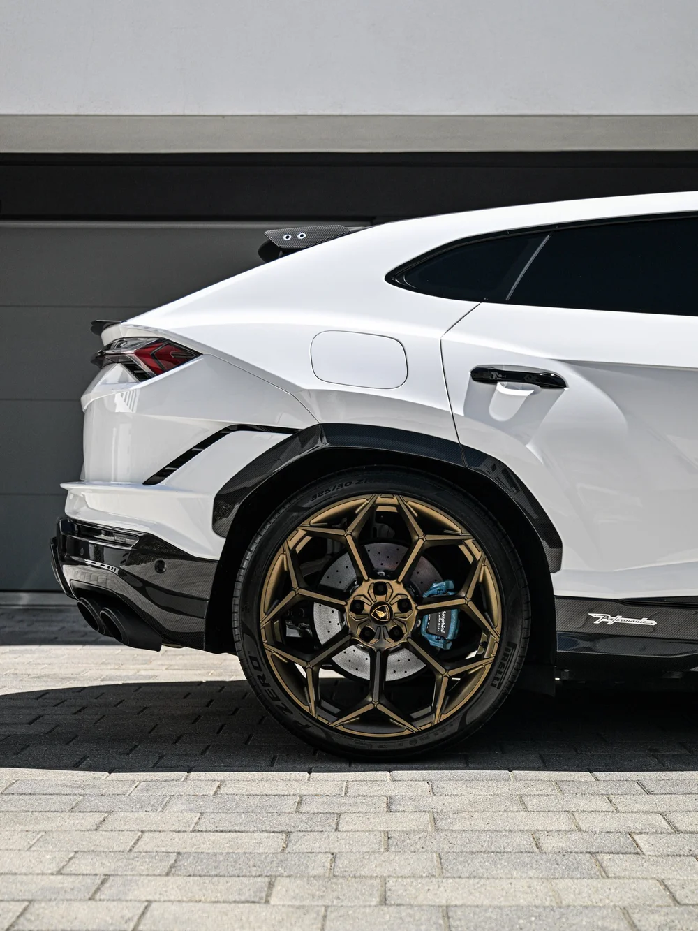 Urus rear quarter with a bronze-toned wheel, dark side window and white door