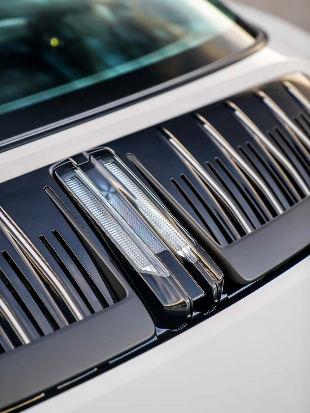 Porsche rear glass above dark engine-cover vents and clear central slats