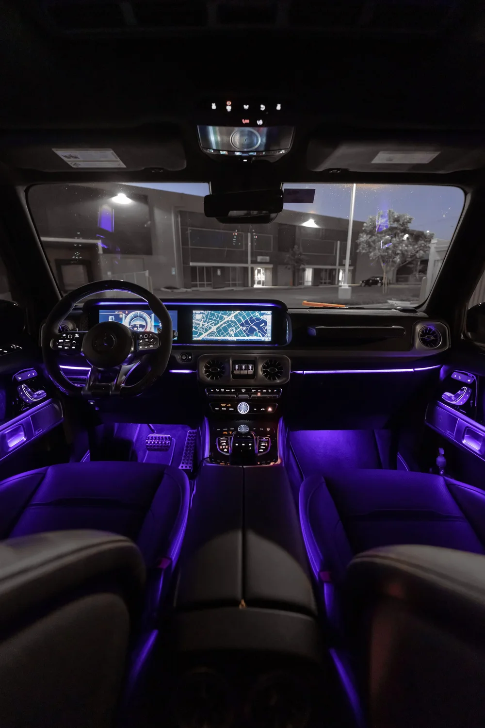 Mercedes-AMG G 63, portrait cabin view with front seats and purple lighting