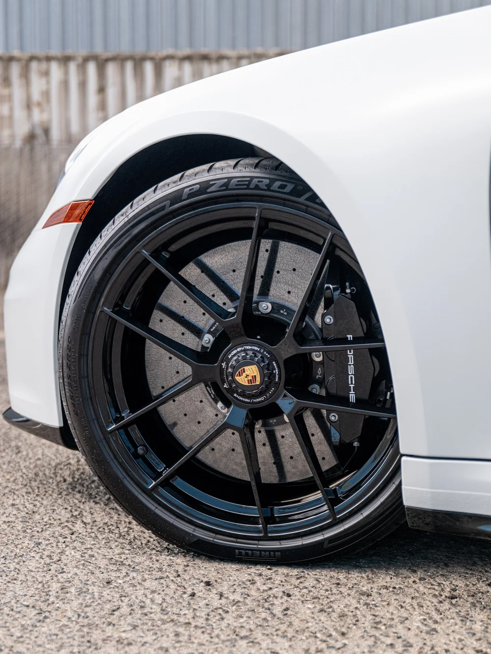 Center-lock front wheel, brake disc and satin-white front fender on a 2026 Porsche 911 Carrera 4 GTS