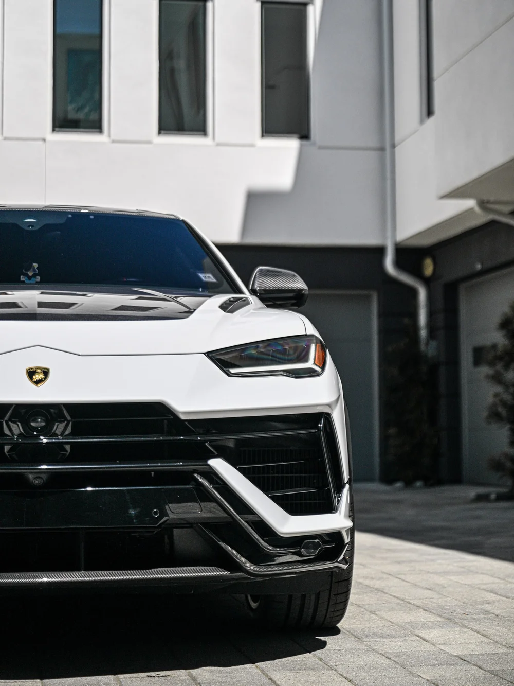 Close Urus front view showing one headlight, white bumper and dark lower intake