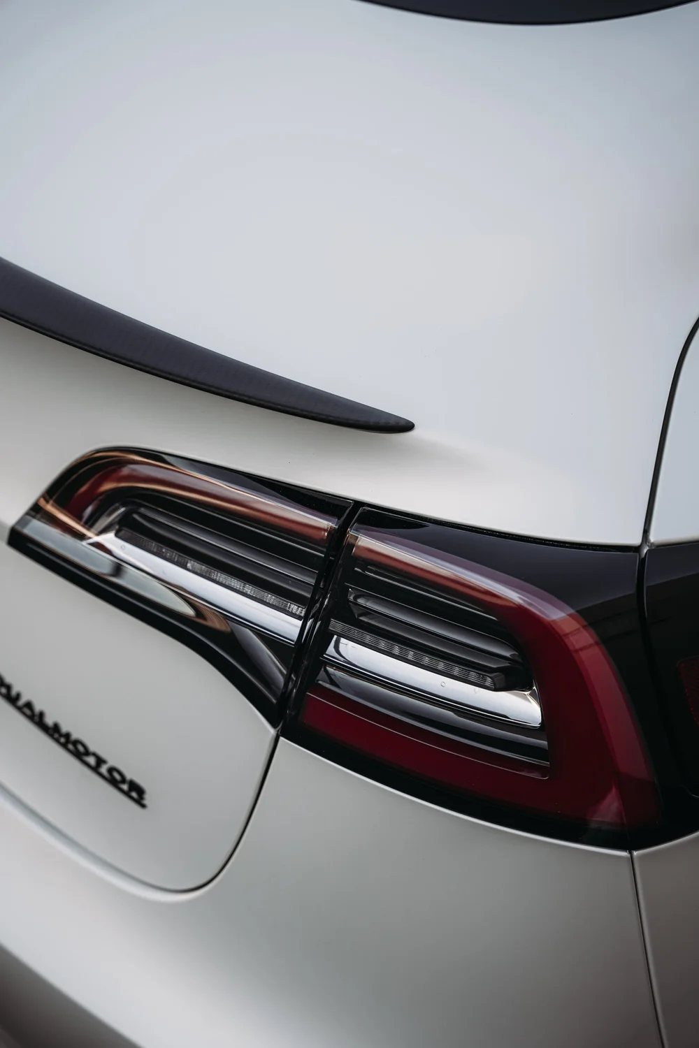 Close rear taillight and trunk-panel detail on the Tesla Model 3 with 3M 2080 Satin Pearl White vinyl