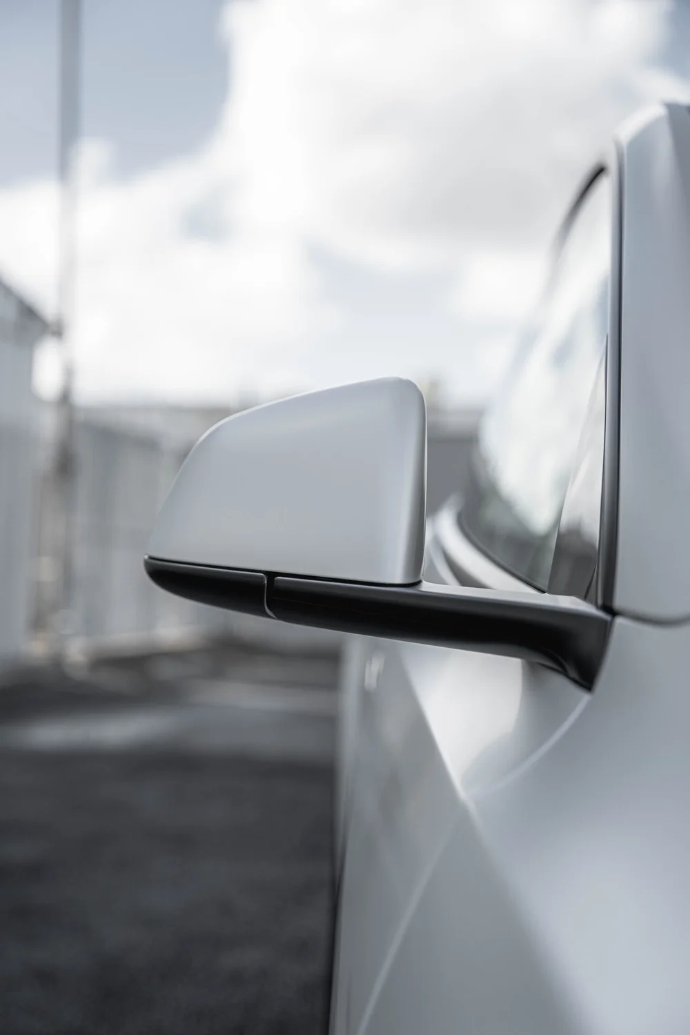 Portrait close view of the Tesla Model Y side mirror and adjoining trim