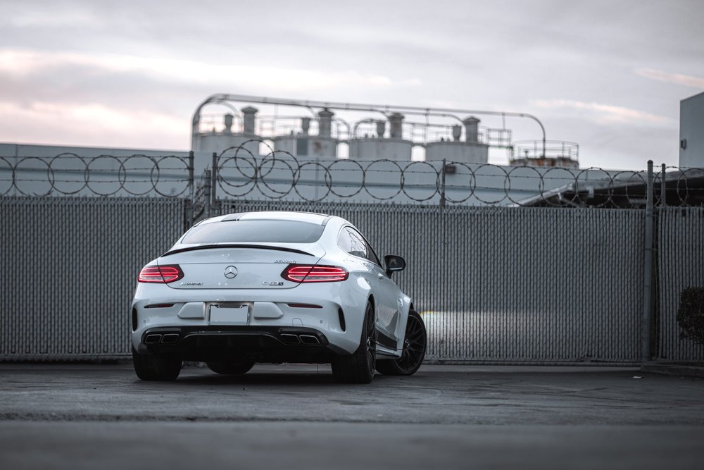 Wide rear three-quarter view of the Mercedes-Benz C 63 showing its rear racing-stripe graphics