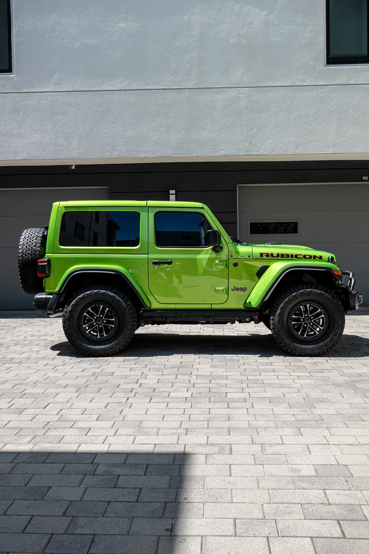 Four-door side profile of the Mojito Wrangler Unlimited Rubicon with a painted roof and rear-mounted spare tire