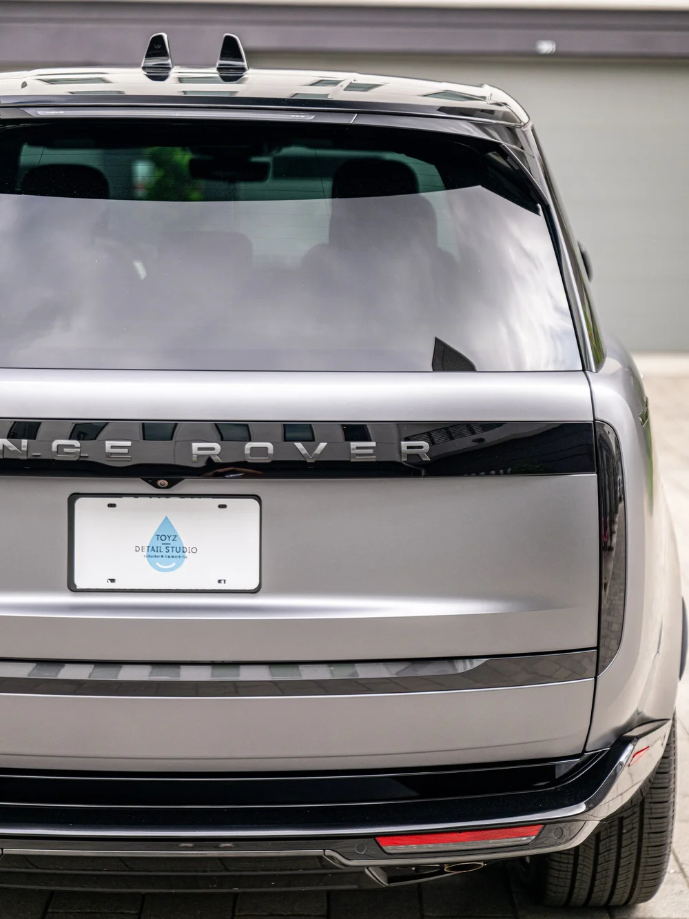 Closer view of the Range Rover tailgate lettering, rear window and gloss black rear light strip.