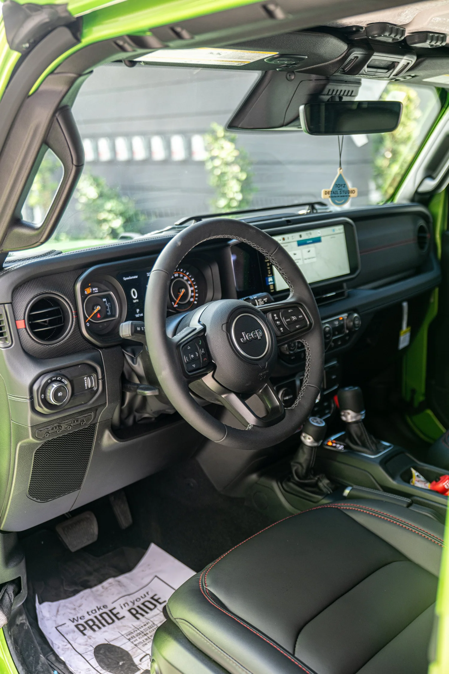 Driver cockpit of the Wrangler Unlimited Rubicon with Jeep steering wheel, instrument cluster and center touchscreen