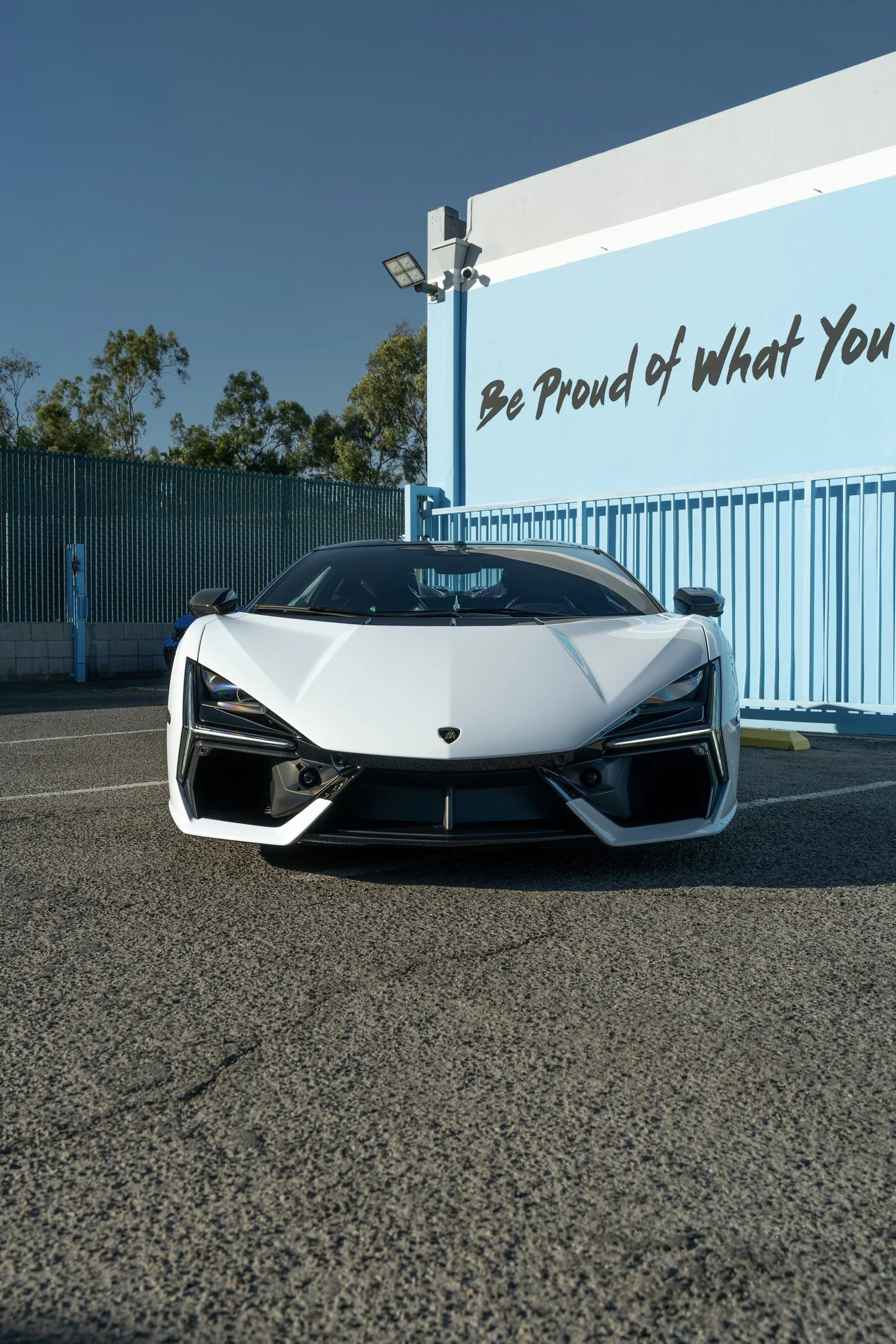 Straight-on front view of the white Lamborghini Revuelto with black front aero.