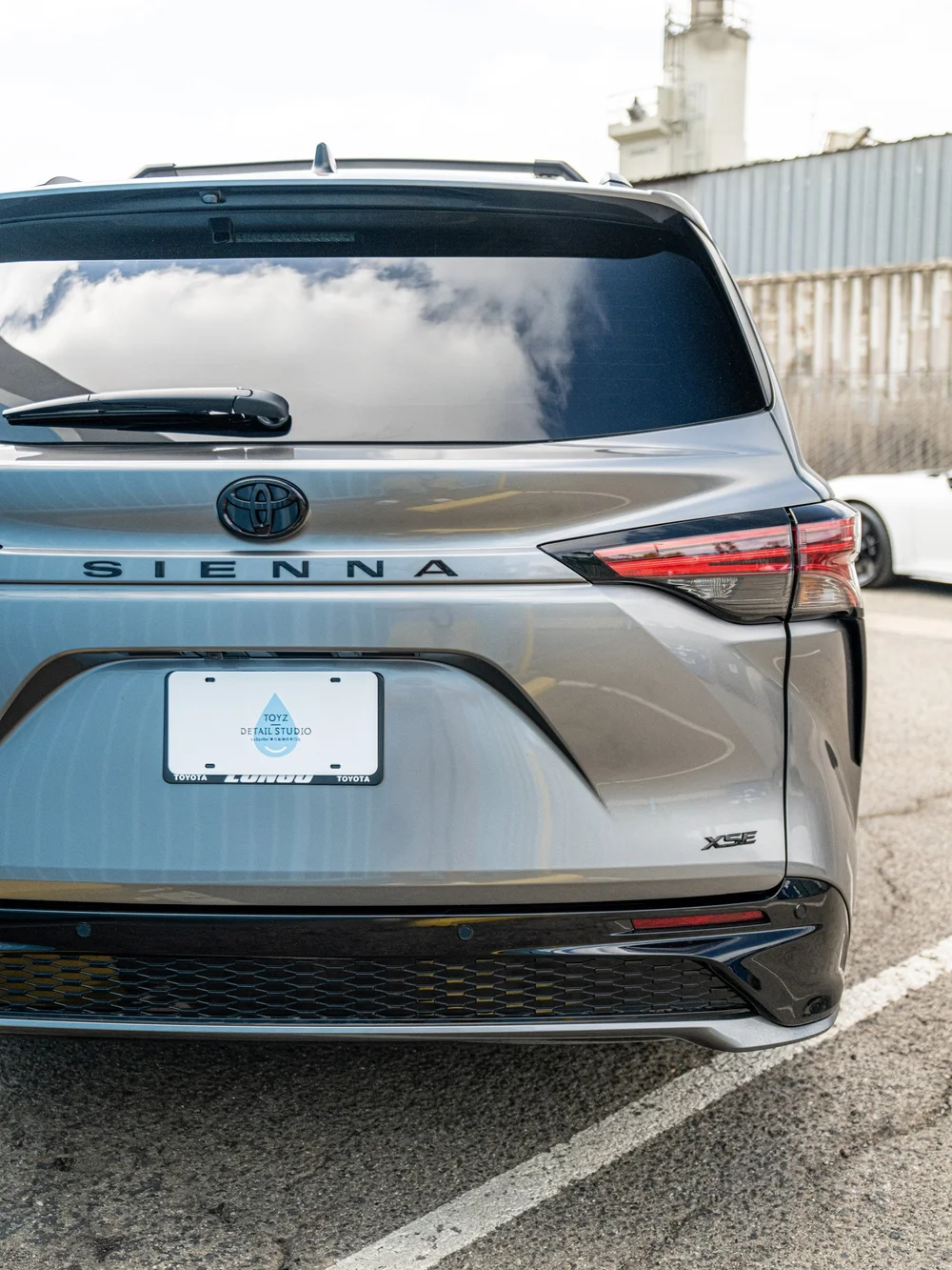 Rear hatch detail of a Heavy Metal 2026 Toyota Sienna XSE with dark rear glass, Sienna lettering and XSE badge