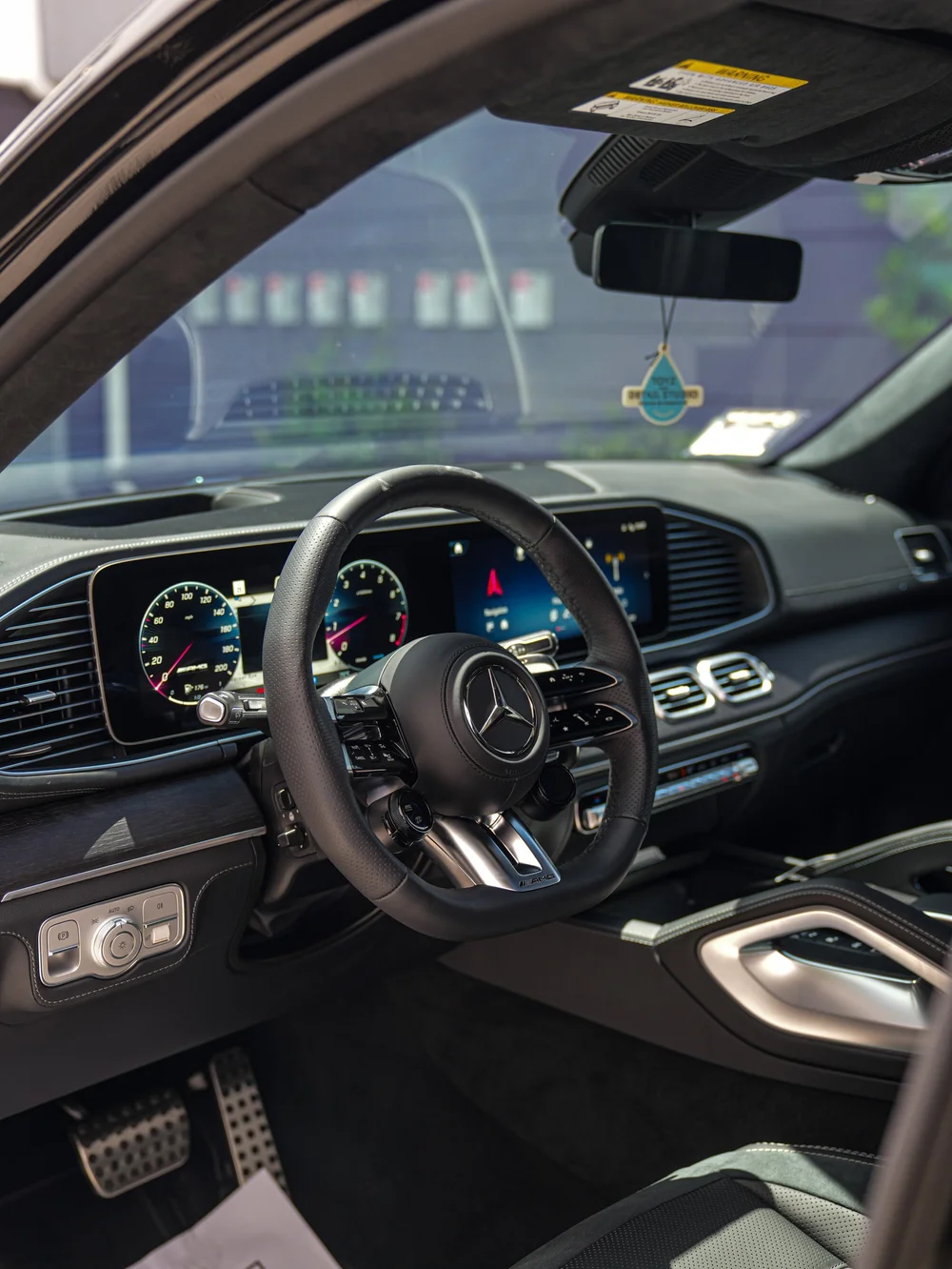 Mercedes-AMG GLS 63 steering wheel, dashboard and center console viewed through the open door