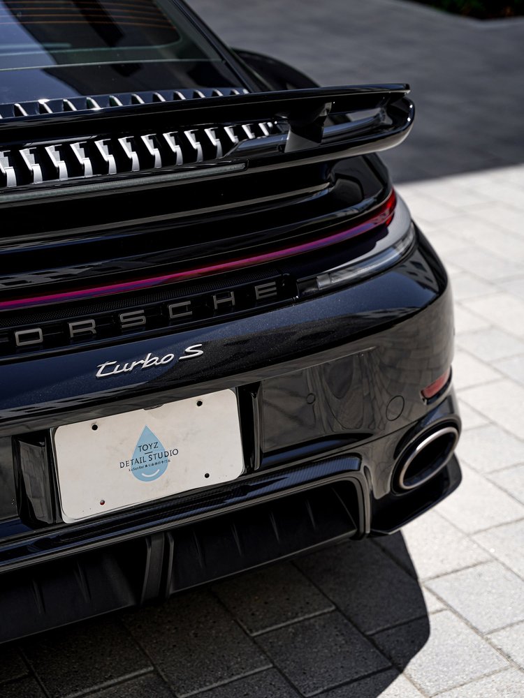 Angled rear detail of the Turbo S light bar, badge, raised wing and bumper.