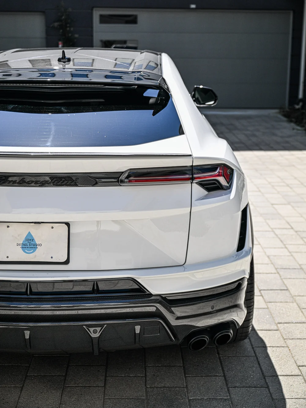 Partial Urus rear view with dark roof glass, taillight and lower bumper trim