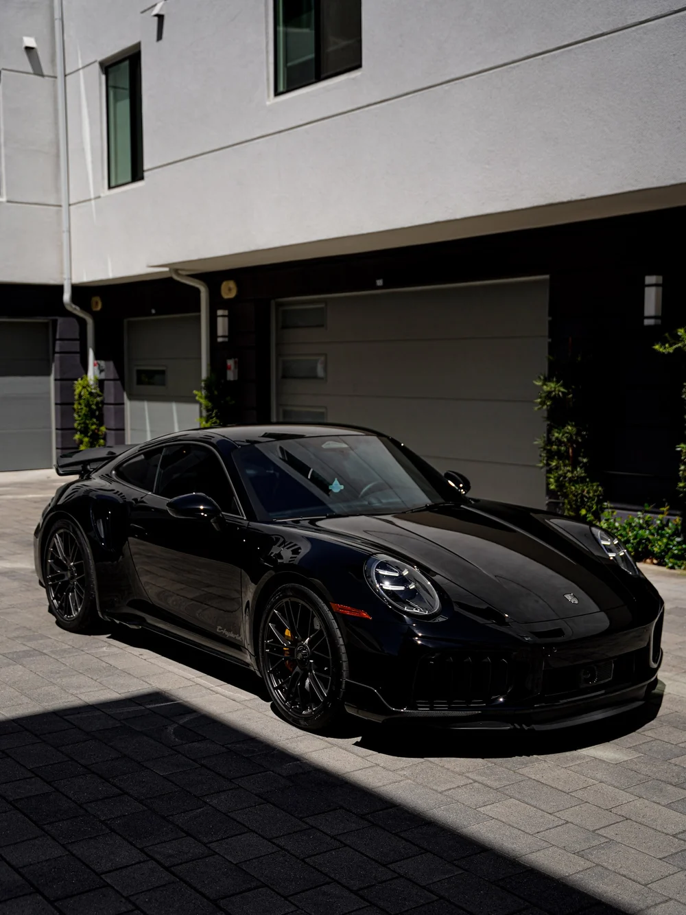 Turbo S front three-quarter view with the windshield and side glass visible across sunlight and shadow.