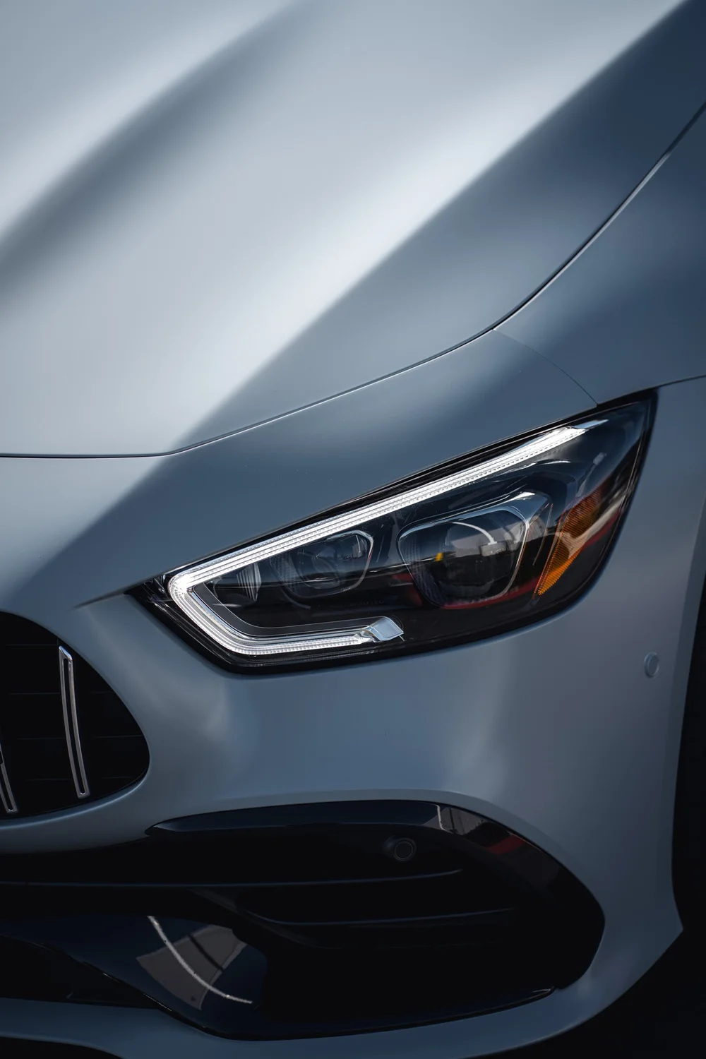 Mercedes-AMG GT 53 hood seam, headlight and front bumper in a portrait close view