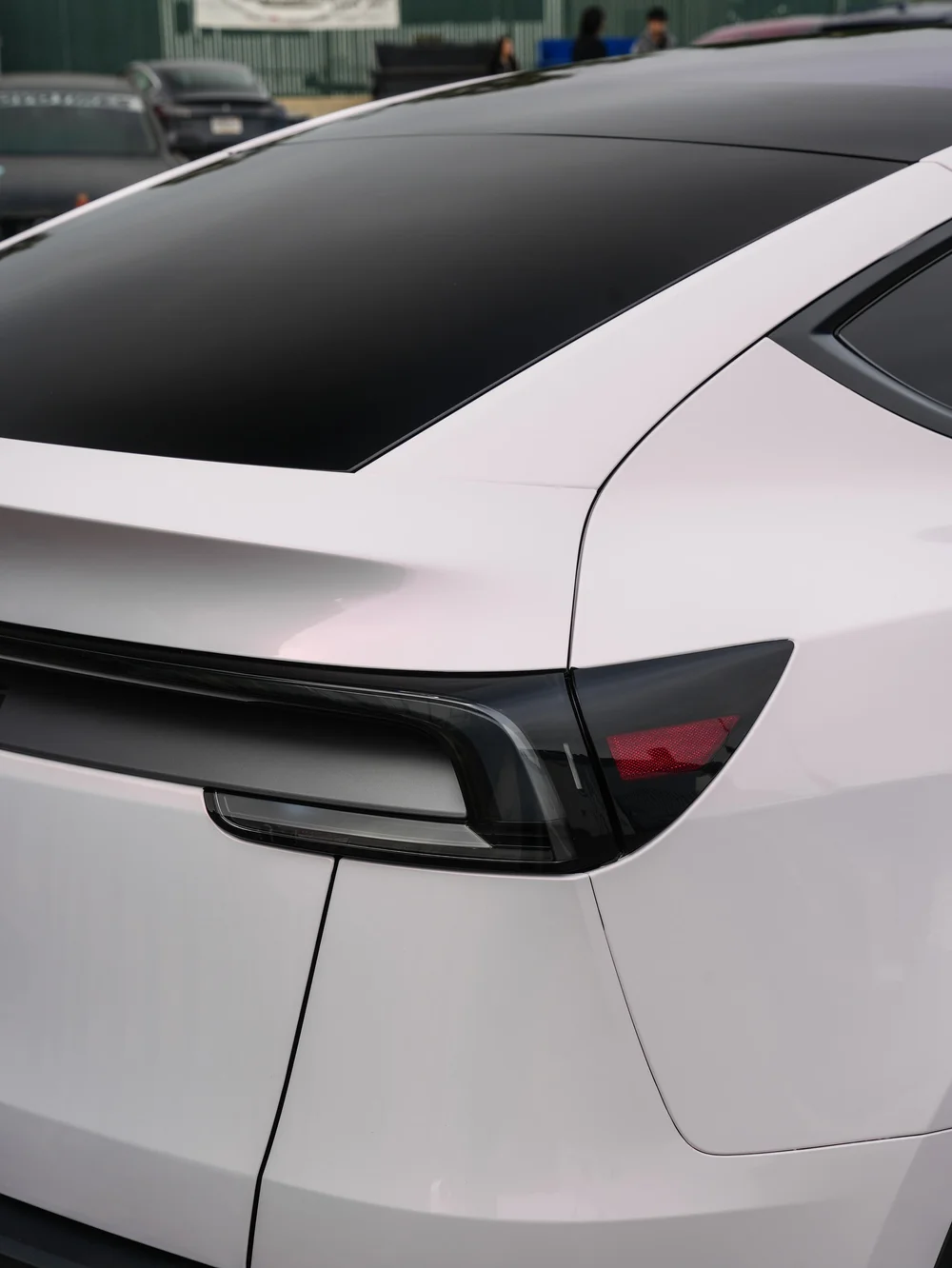 Close rear hatch and light-bar detail on a Tesla Model Y with Pale Blush Pink vinyl