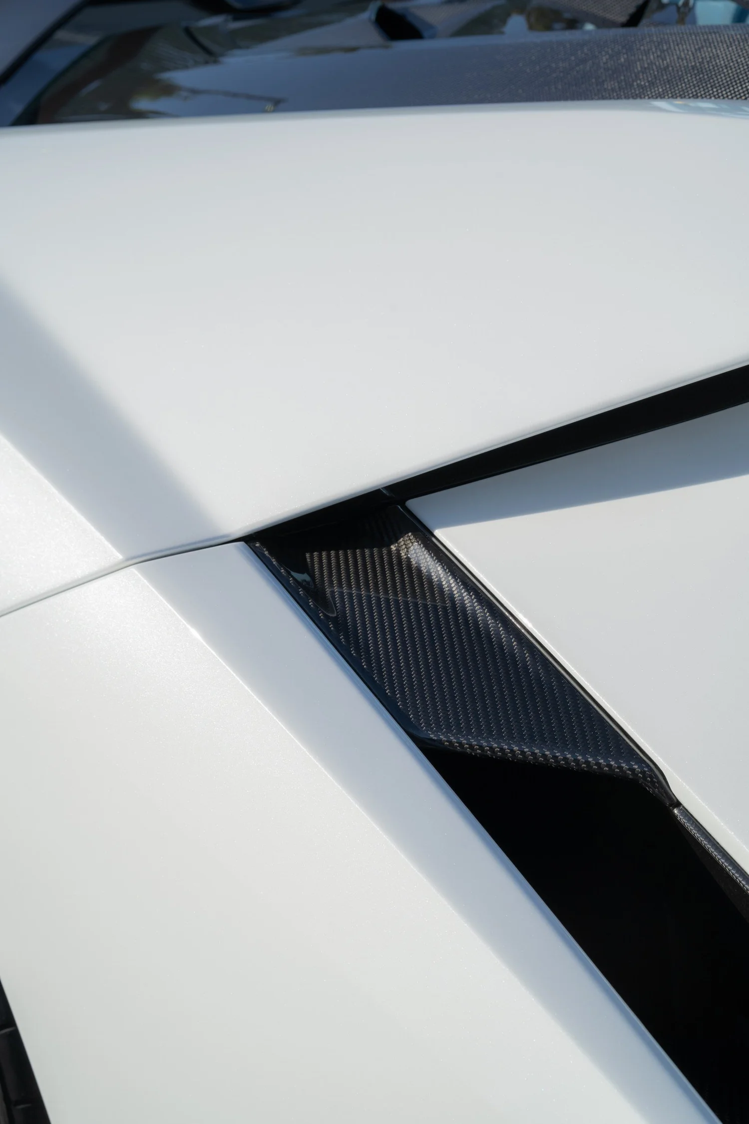 White Revuelto body panel beside exposed carbon trim.